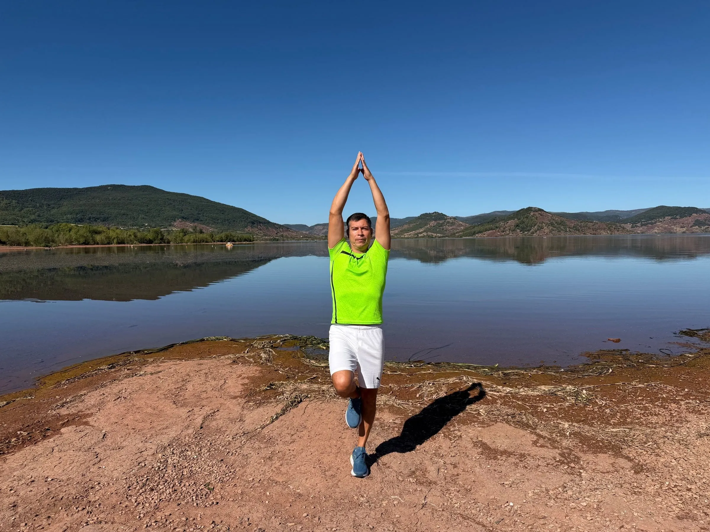 Anibal Mosquera en posture d'équilibre au bord du lac du Salagou